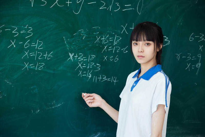 上课时在教室黑板解答数学习题的高中生