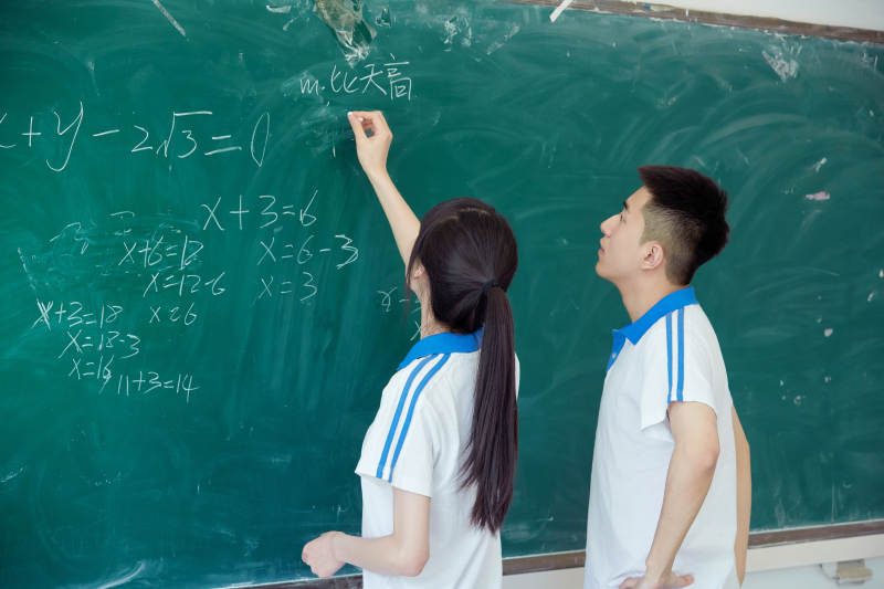 上课时在教室黑板解答数学习题的高中生