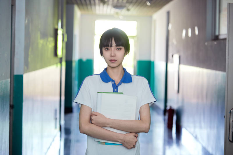 学校走廊里抱着书本的女高中生