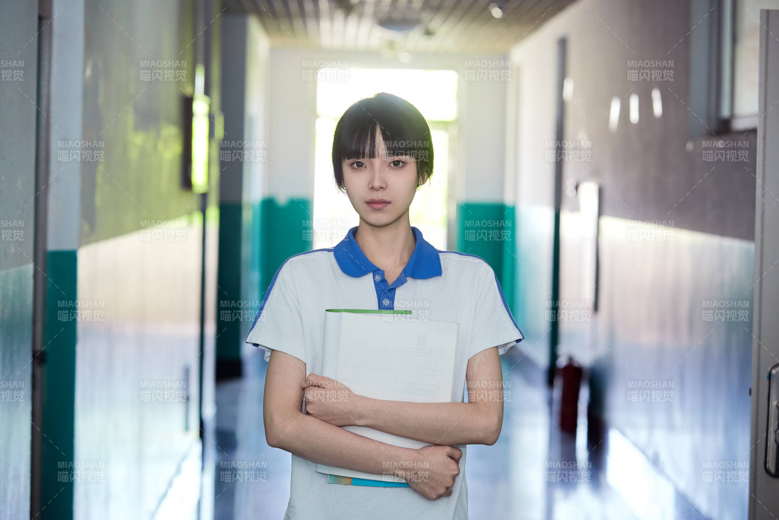学校走廊里抱着书本的女高中生