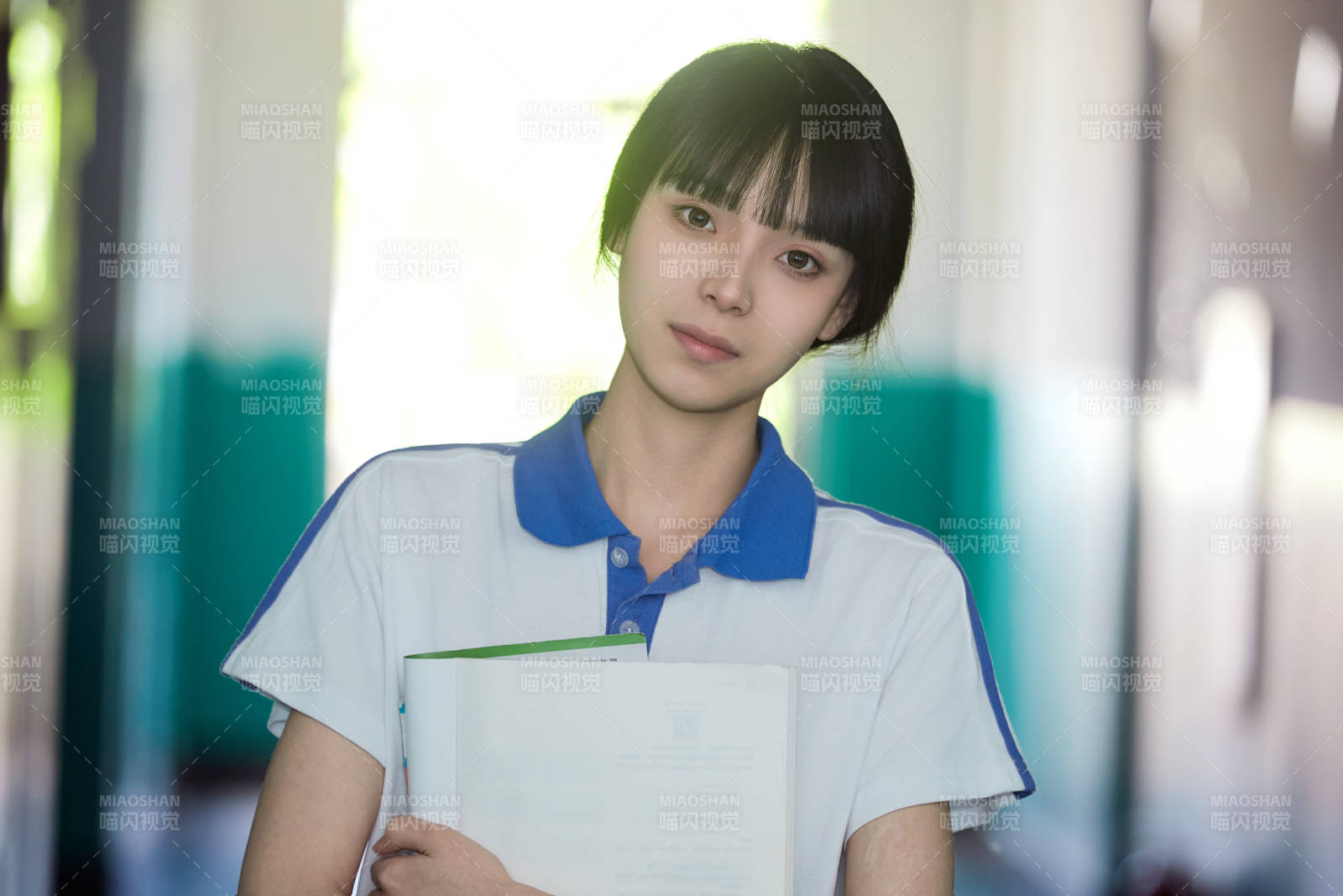 学校走廊里抱着书本的女高中生