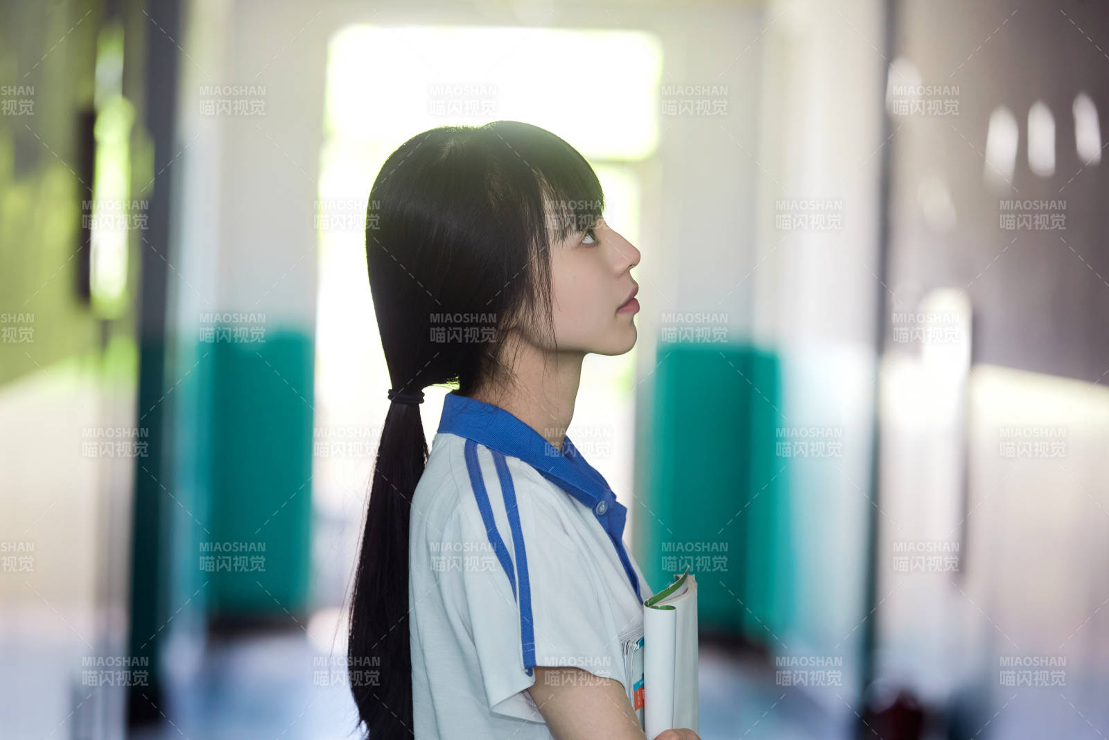 学校走廊里抱着书本的女高中生