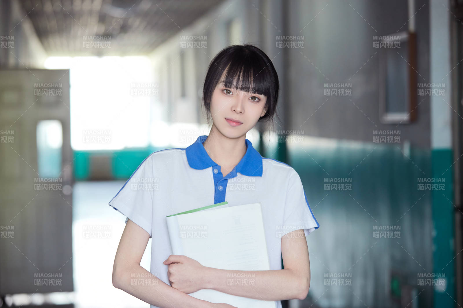 学校走廊里抱着书本的女高中生
