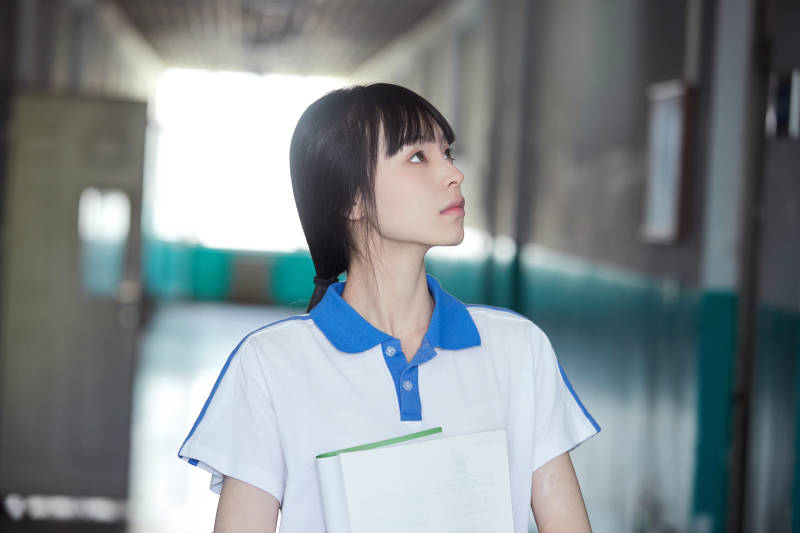 学校走廊里抱着书本的女高中生