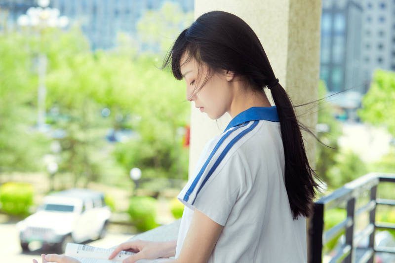 在学校教学楼阳台复习看书的高中生