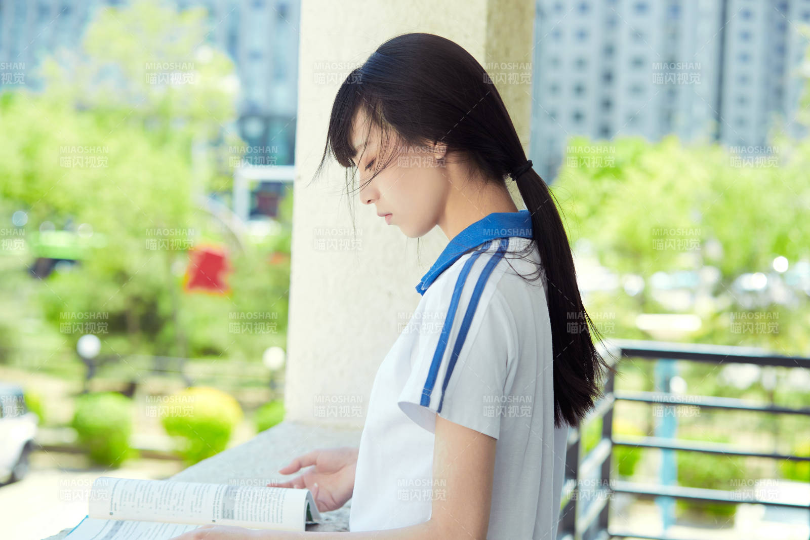 在学校教学楼阳台复习看书的高中生