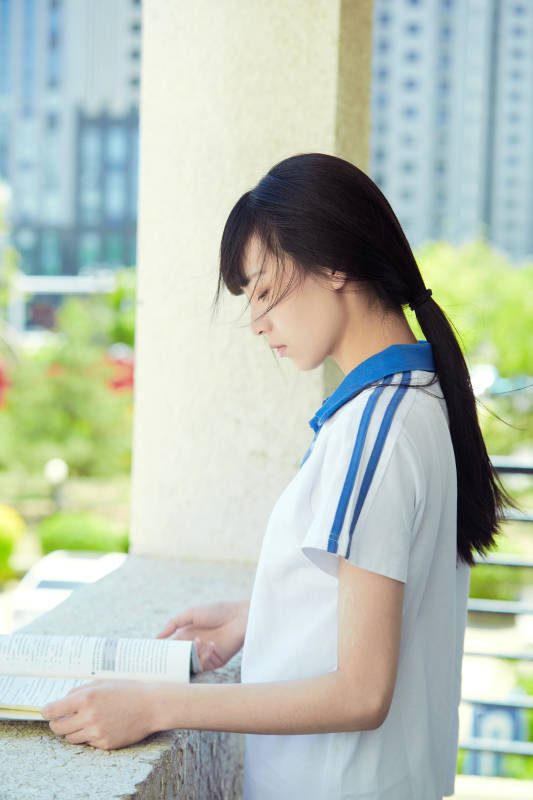 在学校教学楼阳台复习看书的高中生