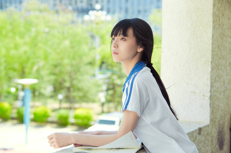 在学校教学楼阳台复习看书的高中生