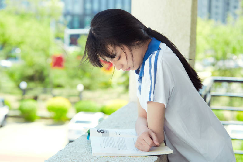 在学校教学楼阳台复习看书的高中生