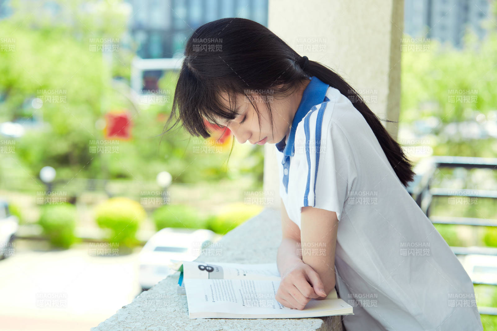 在学校教学楼阳台复习看书的高中生