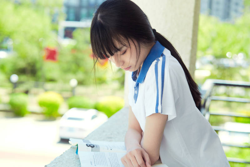 在学校教学楼阳台复习看书的高中生
