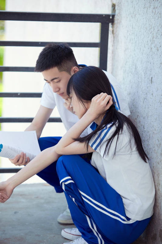 在学校教学楼阳台复习看书的高中生