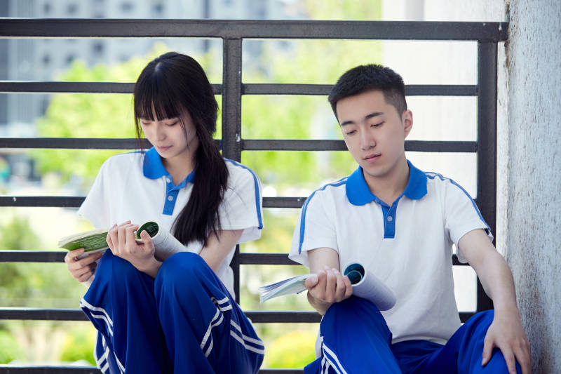 在学校教学楼阳台复习看书的高中生