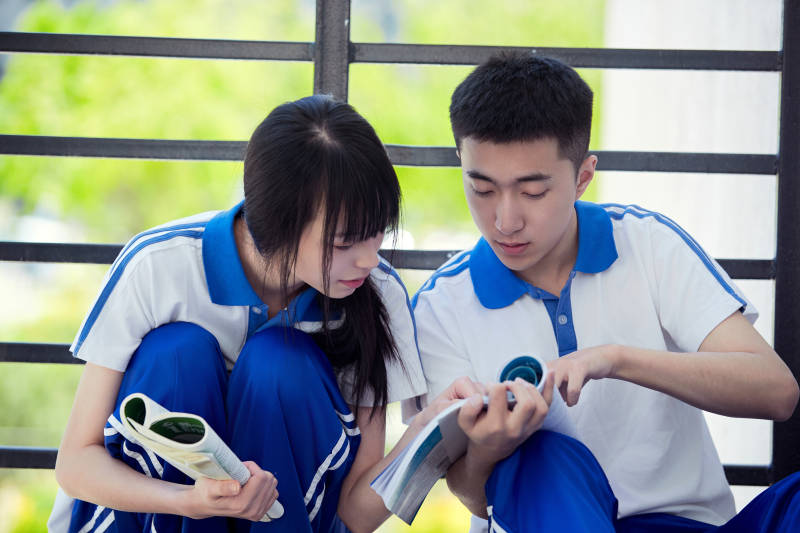 在学校教学楼阳台复习看书的高中生