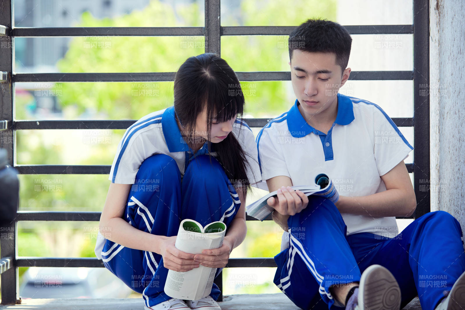在學校教學樓陽臺復習看書的高中生