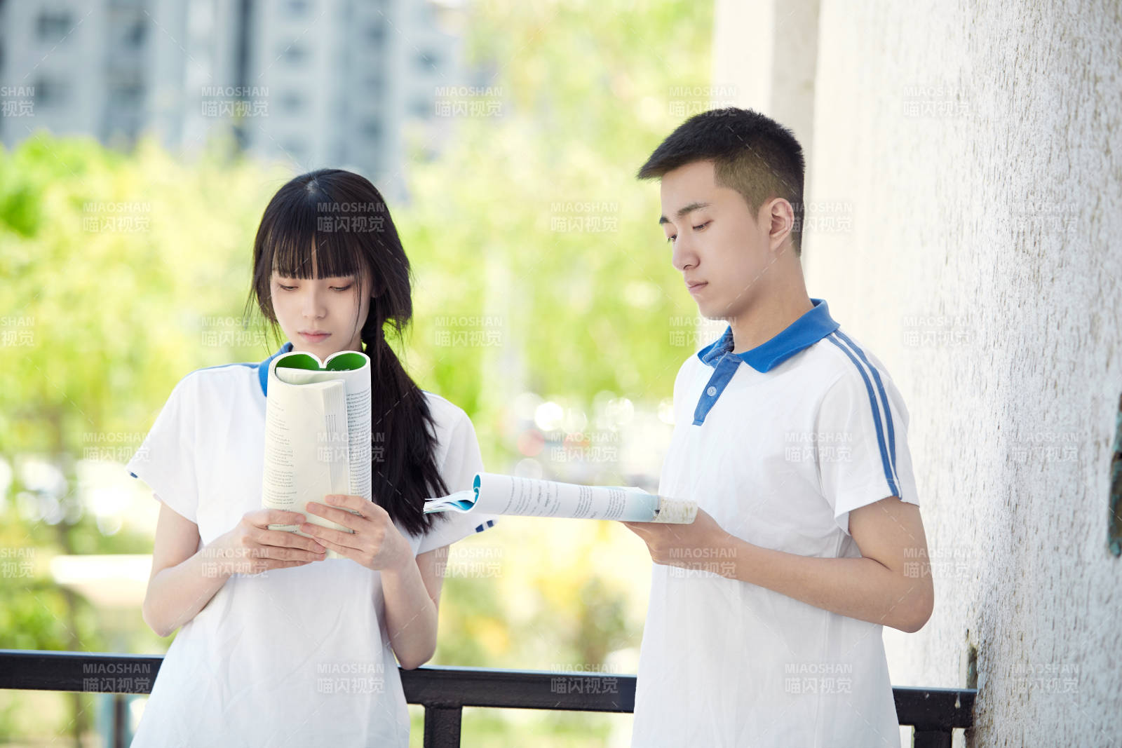 在学校教学楼阳台复习看书的高中生