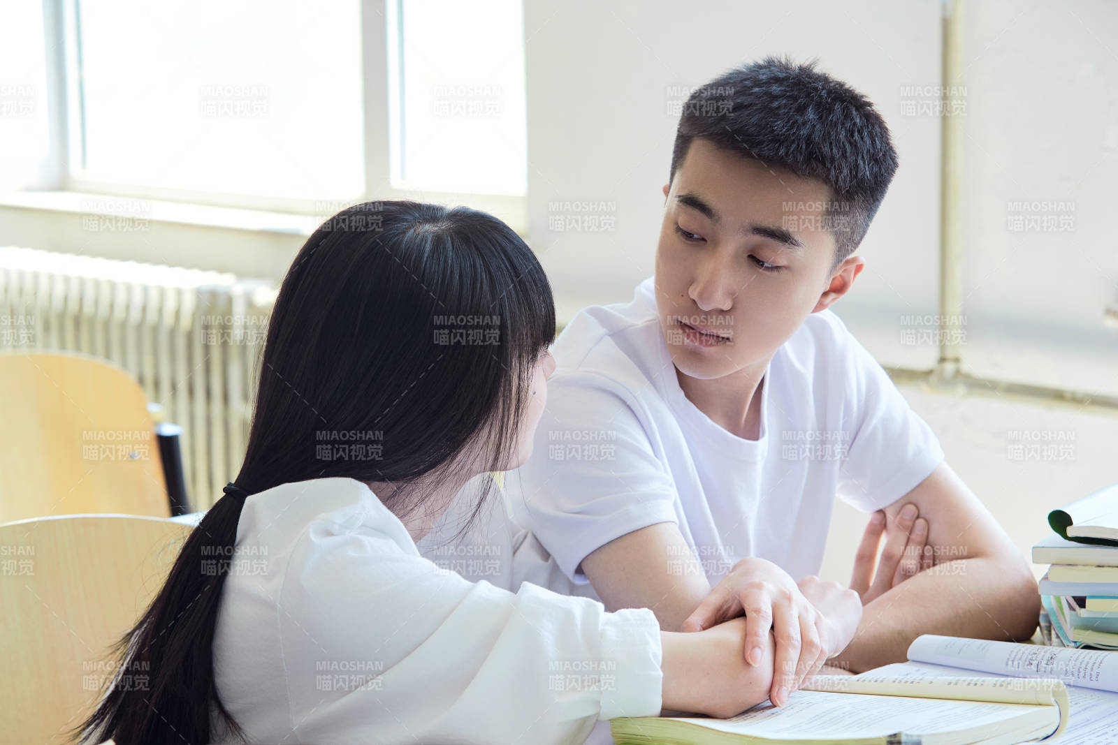 大学自习室相互依偎的青年情侣