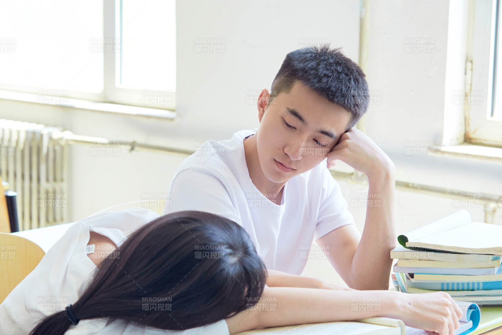 大学自习室相互依偎的青年情侣