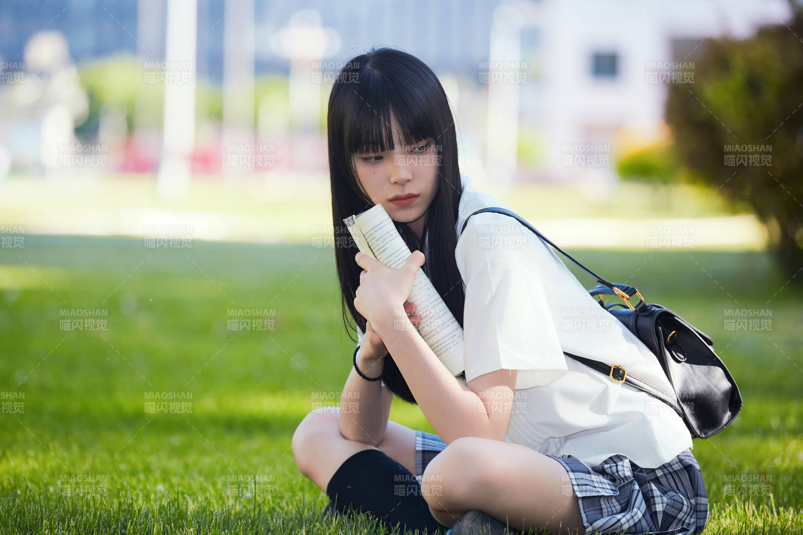 在戶外草坪看書學習的女生