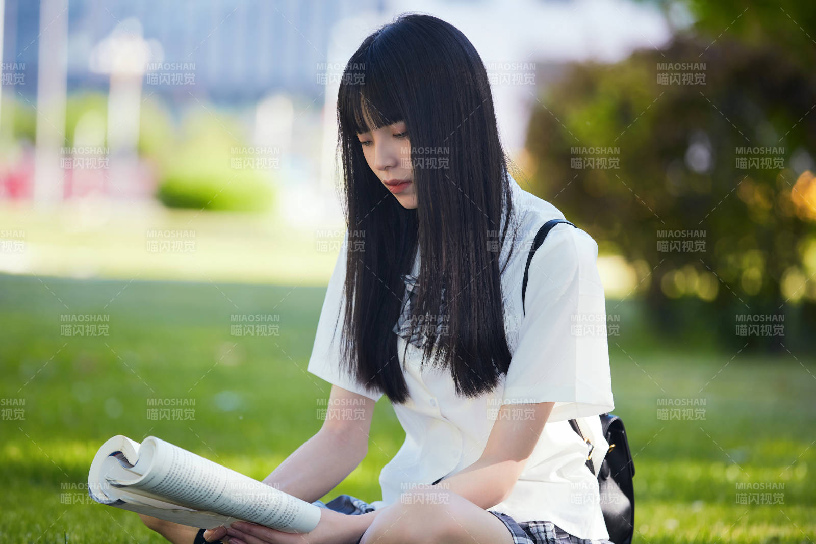 在户外草坪看书学习的女生图片