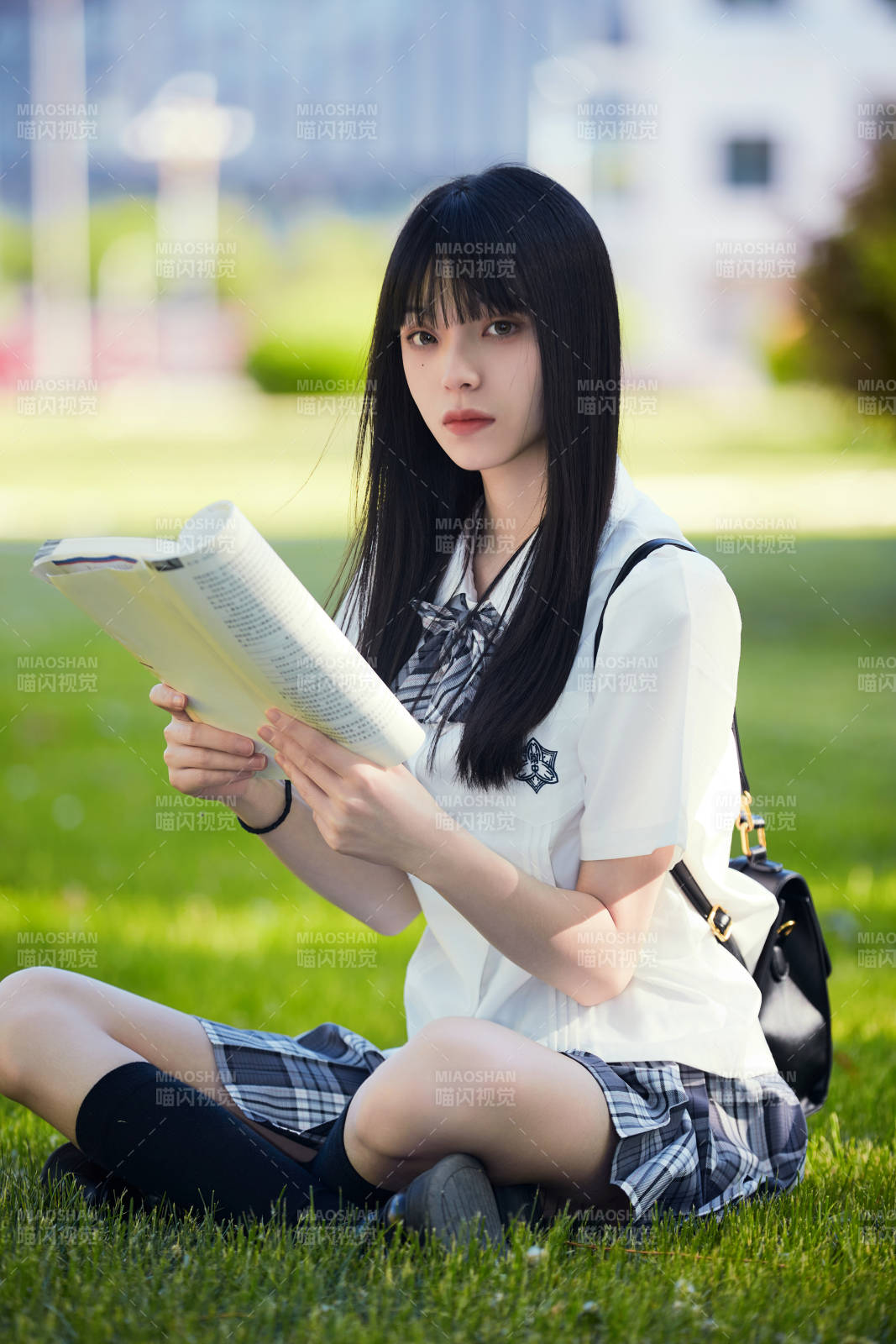 在戶外草坪看書學習的女生