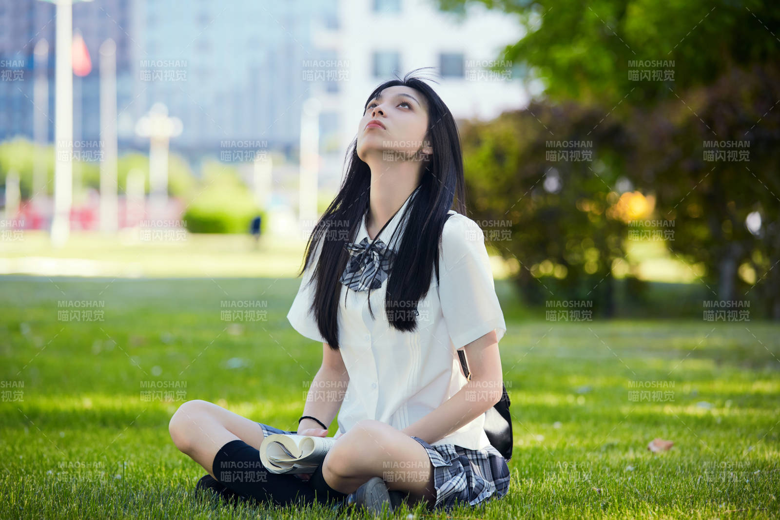 在户外草坪看书学习的女生