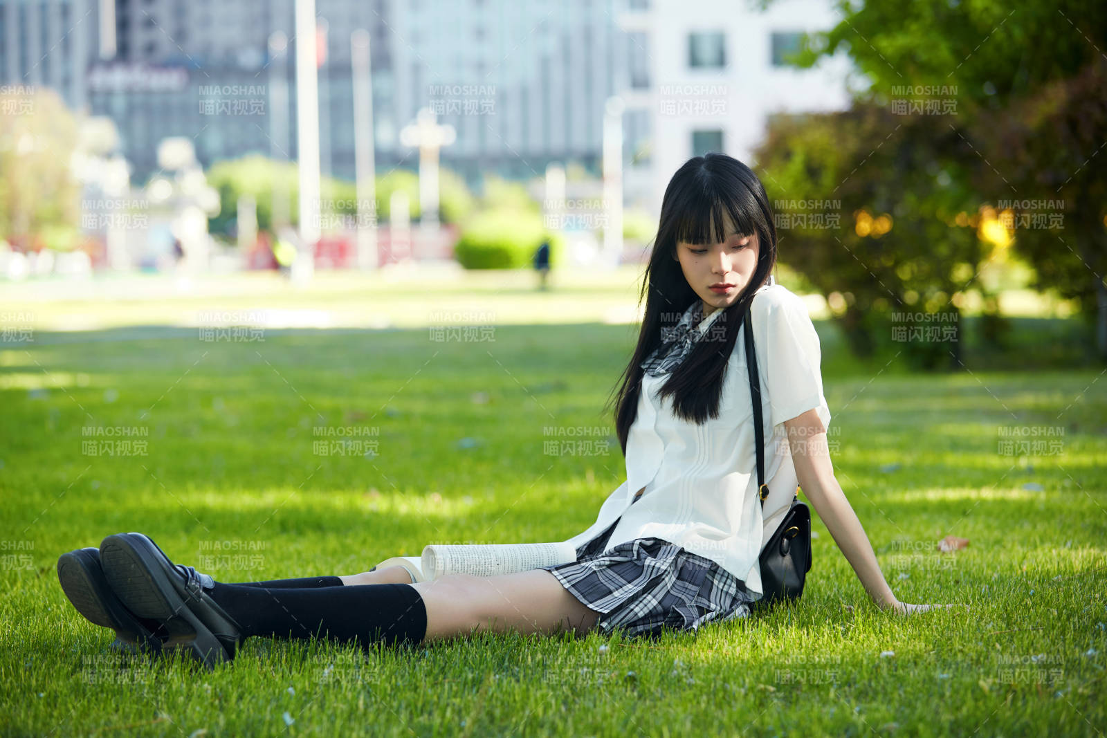 在戶外草坪看書學習的女生