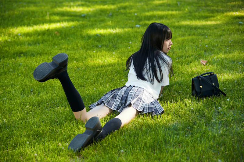 在户外草坪看书学习的女生