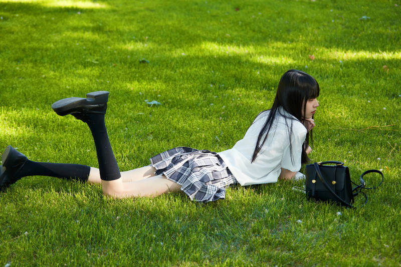 在户外草坪看书学习的女生