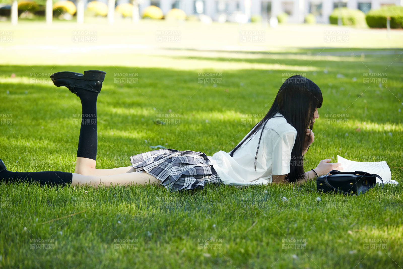 在户外草坪看书学习的女生