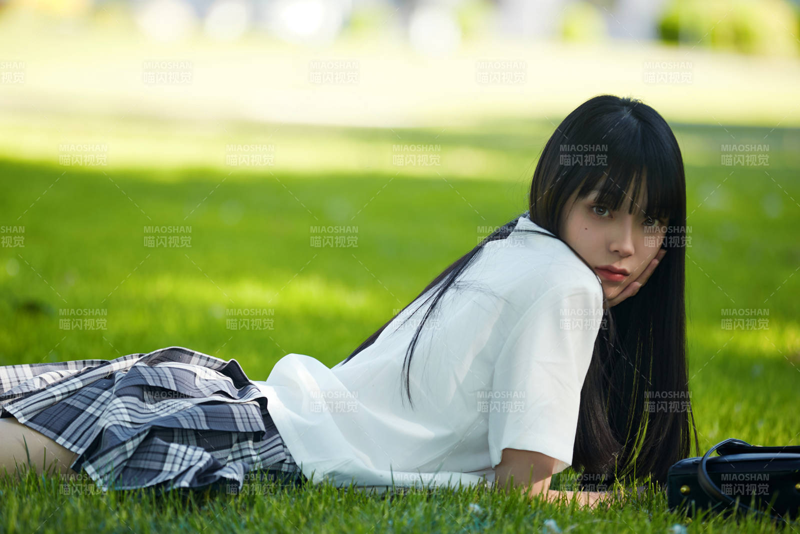 在户外草坪看书学习的女生