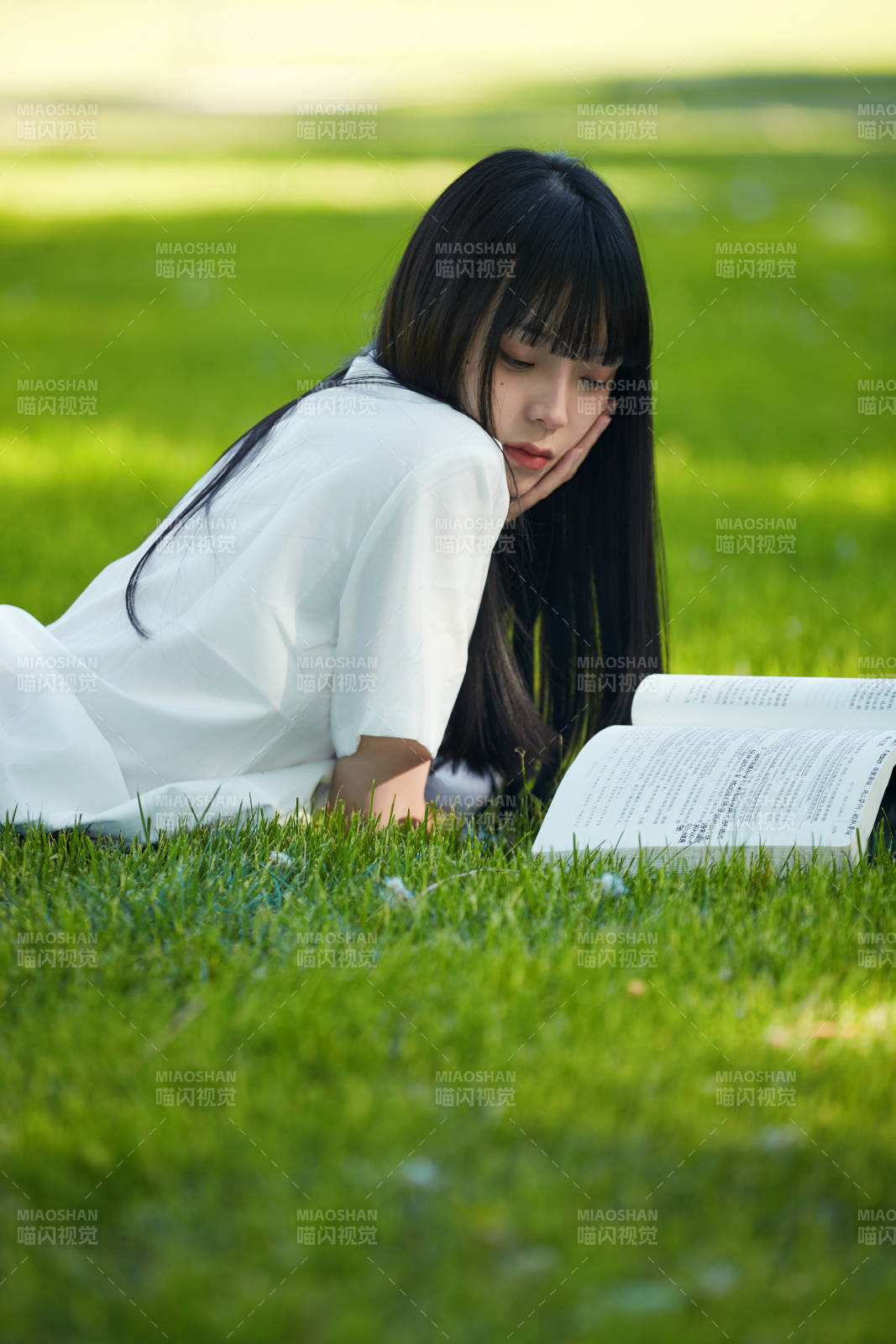 在户外草坪看书学习的女生图片