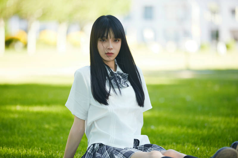 在户外草坪看书学习的女生