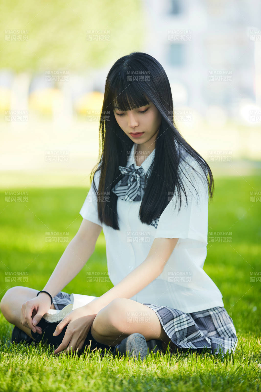 在戶外草坪看書學習的女生