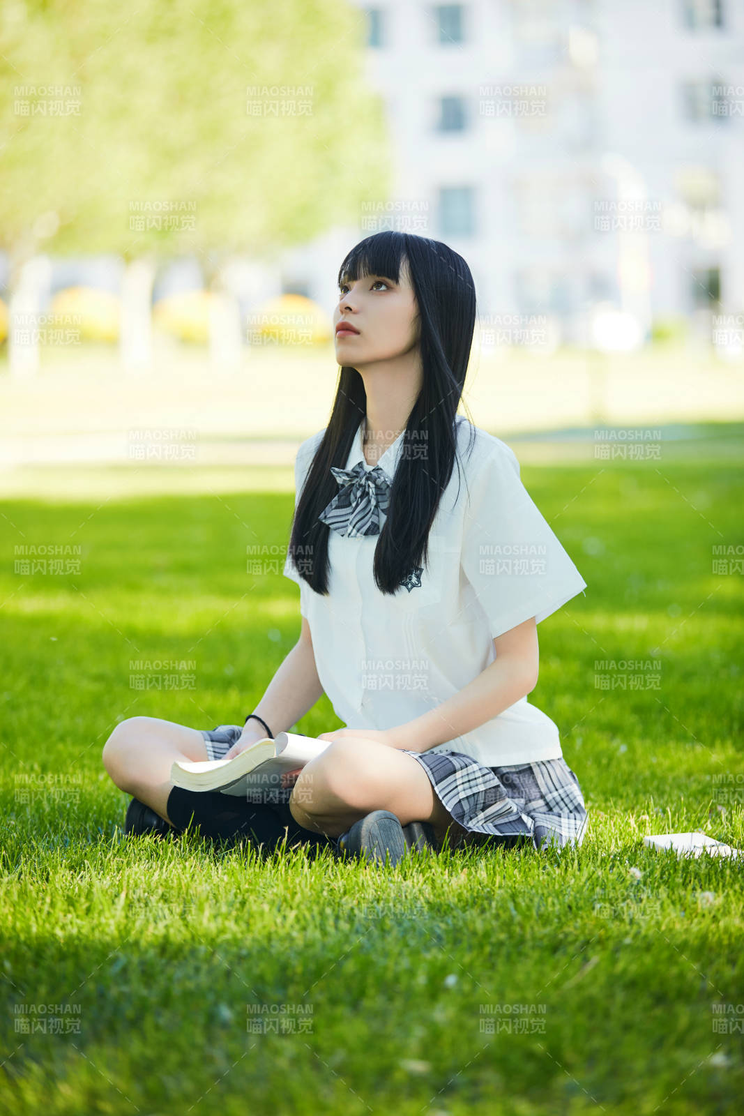 在戶外草坪看書學習的女生