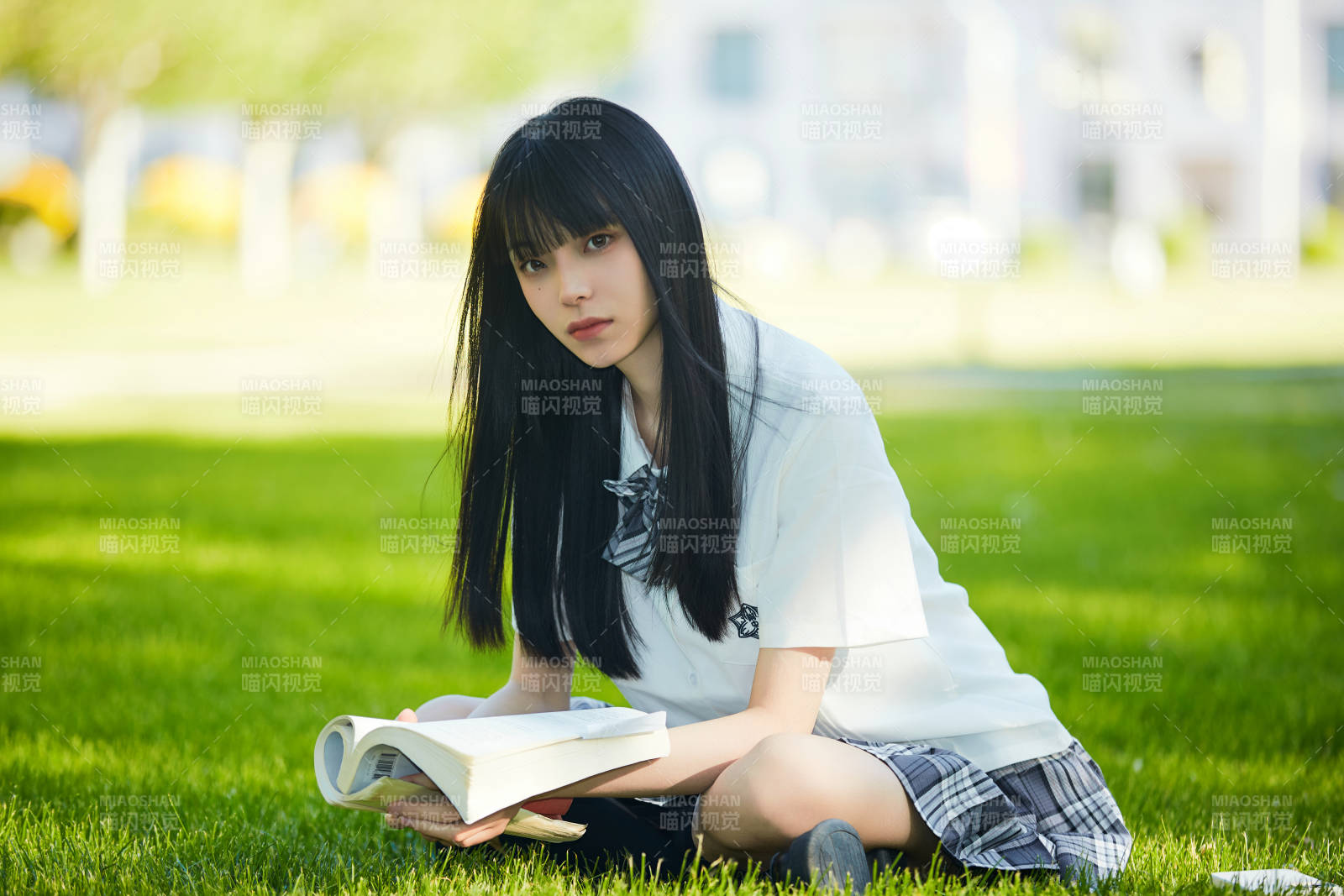 在户外草坪看书学习的女生