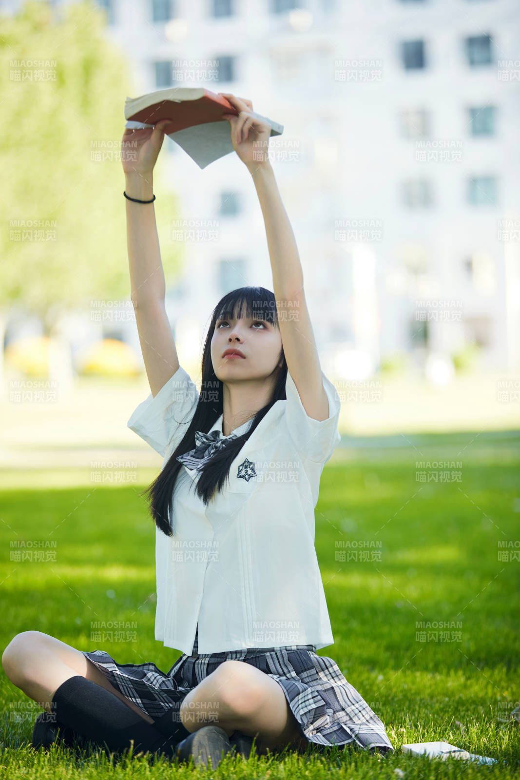 在户外草坪看书学习的女生