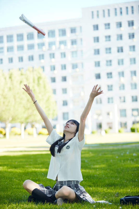 在户外草坪看书学习的女生