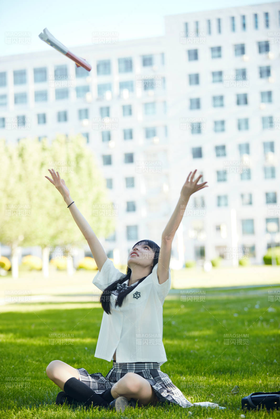 在户外草坪看书学习的女生