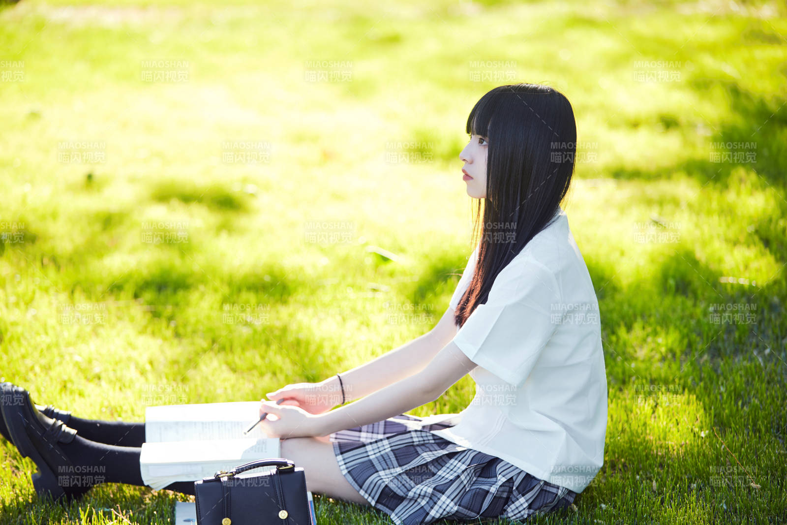 在户外草坪看书学习的女生