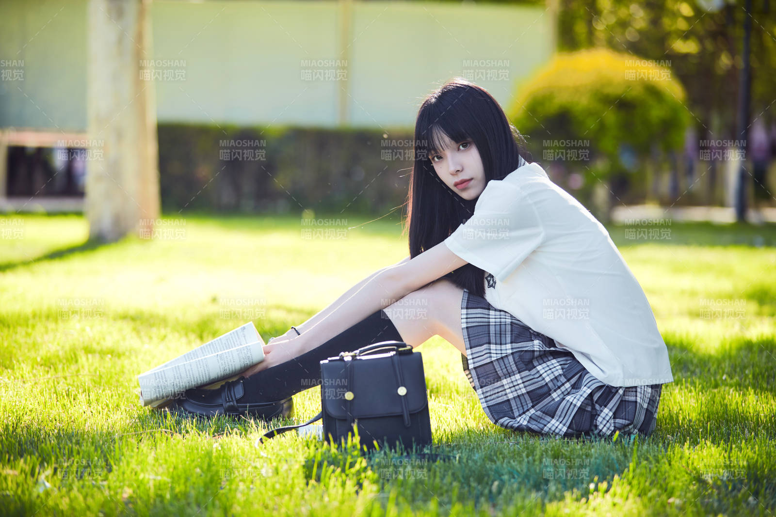 在户外草坪看书学习的女生