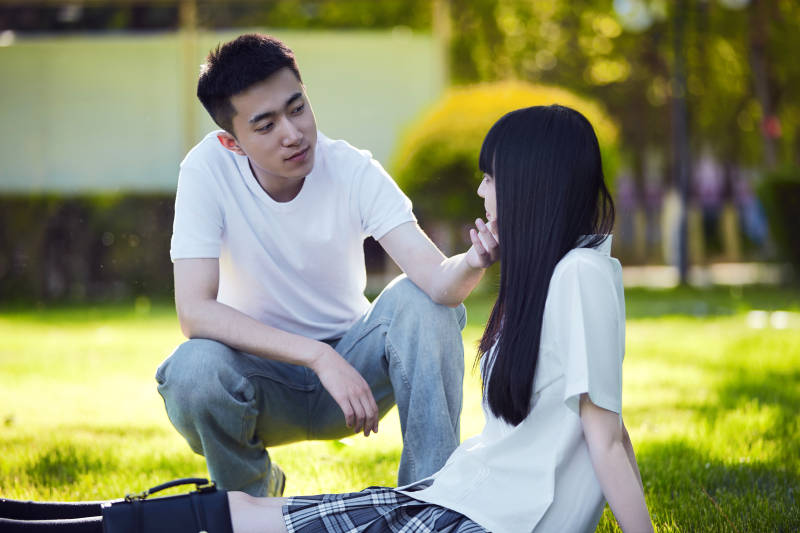 在户外草坪看书学习的女生