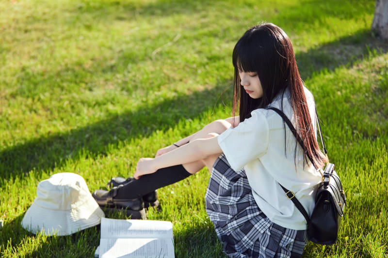 在戶外草坪看書學習的女生