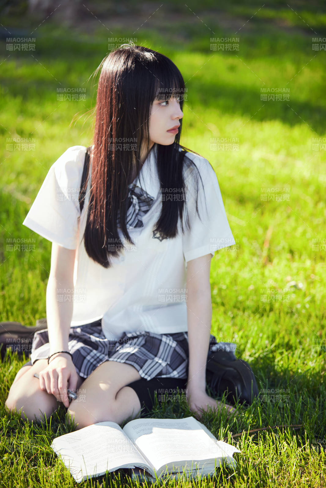 在戶外草坪看書學習的女生