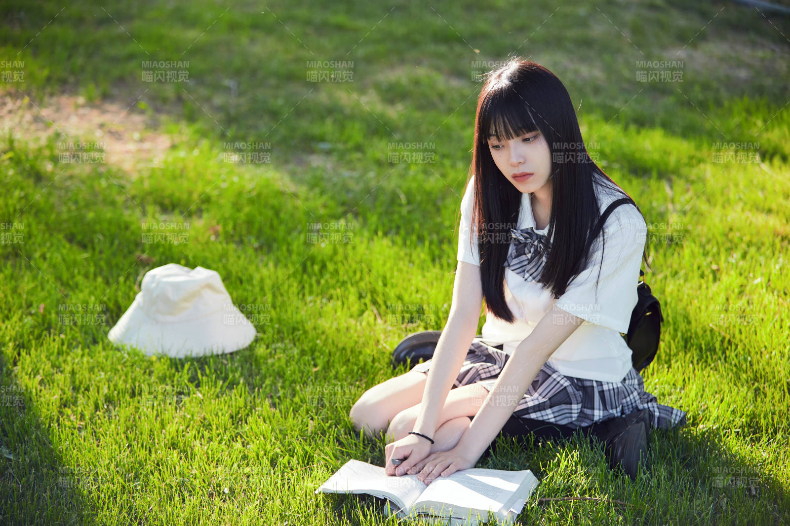 在户外草坪看书学习的女生