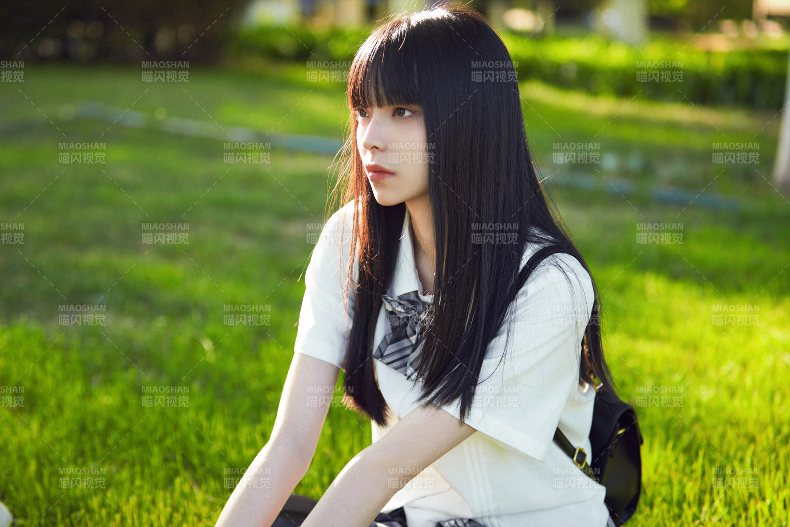 在户外草坪看书学习的女生