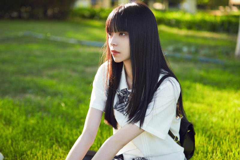 在户外草坪看书学习的女生