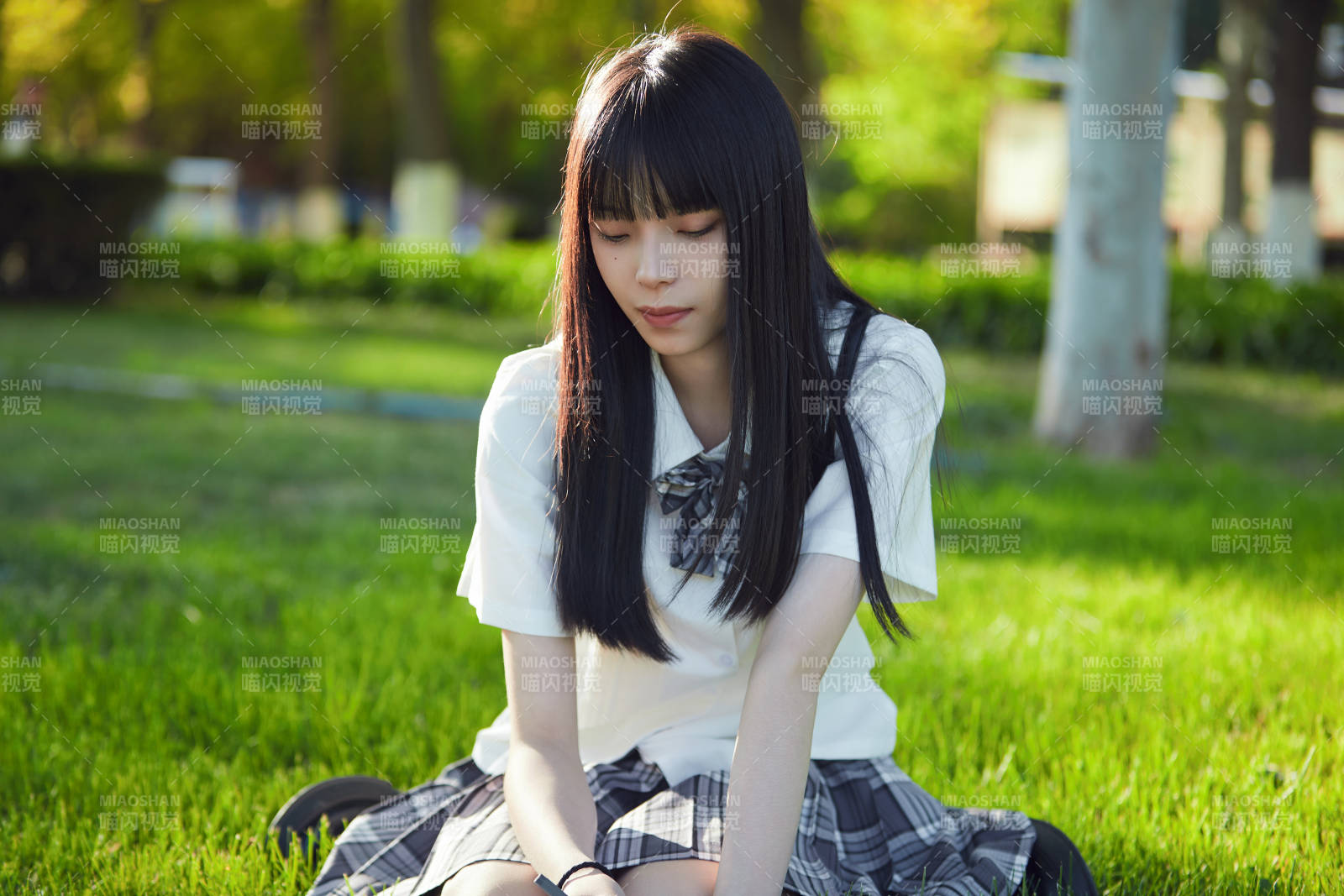 在戶外草坪看書學(xué)習(xí)的女生