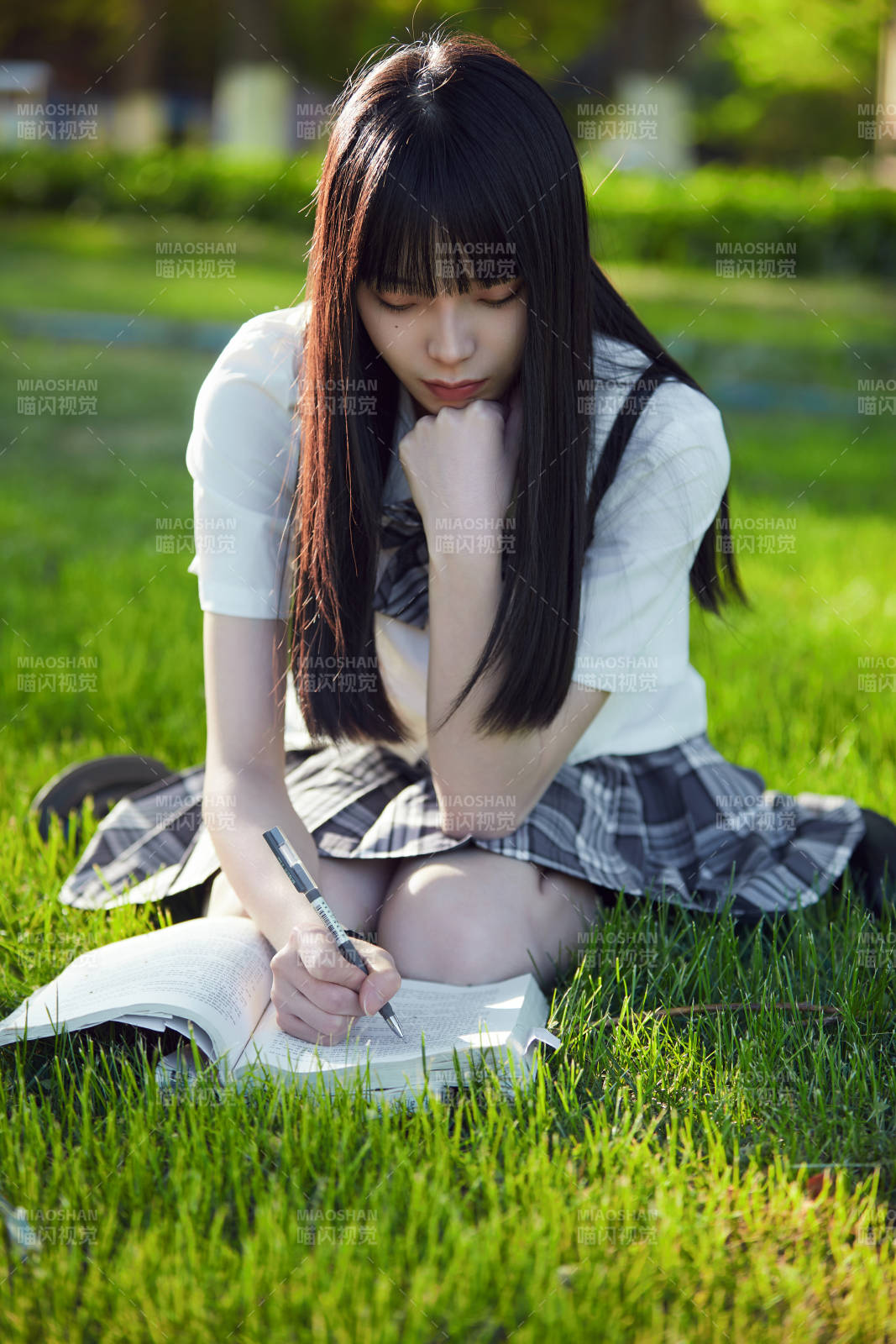 在户外草坪看书学习的女生