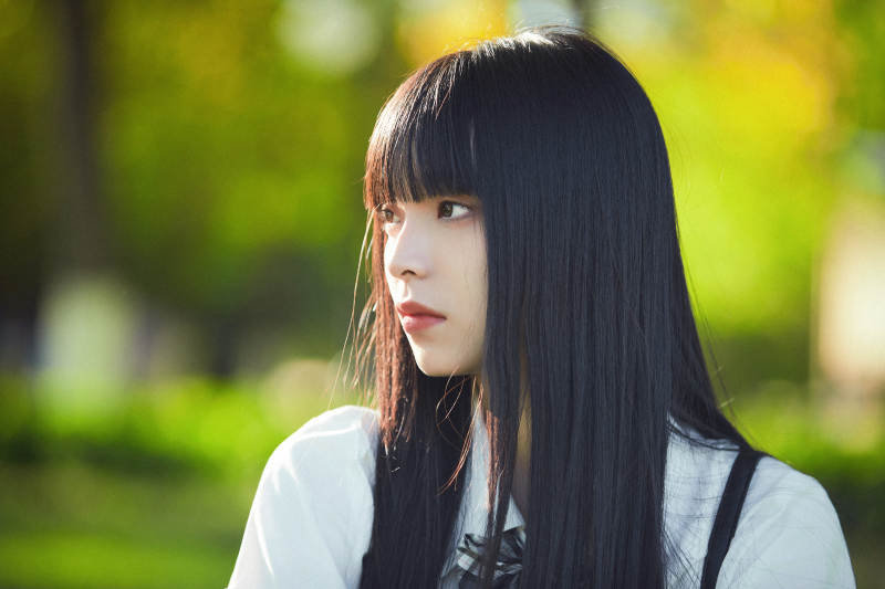 在户外草坪看书学习的女生